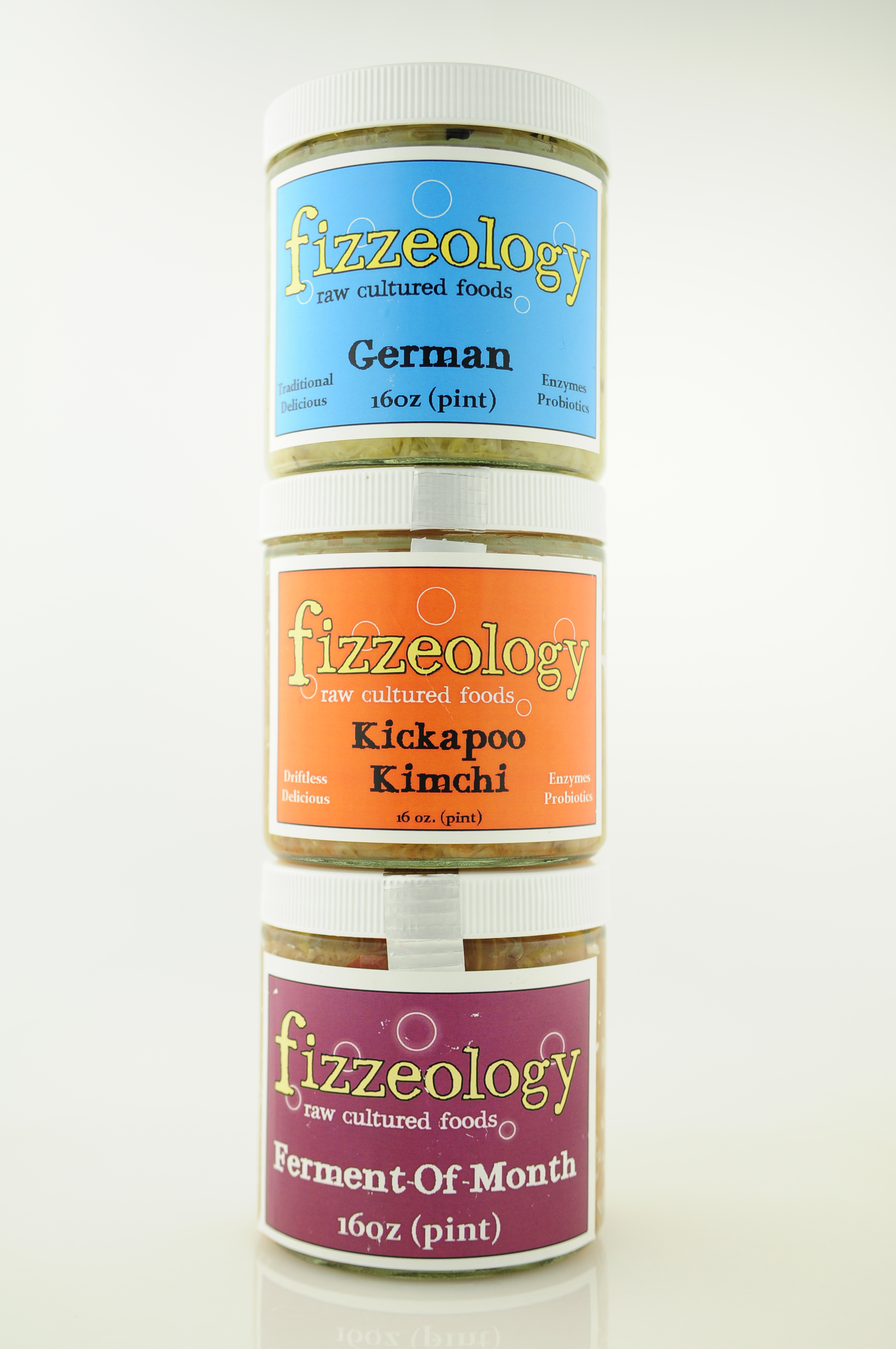 A tower of three jars fermented sauerkraut, stacked one on top of the other, with colorful labels.