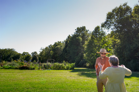 Nathan Larson speaks to a woman in front of a Community GroundWorks garden.