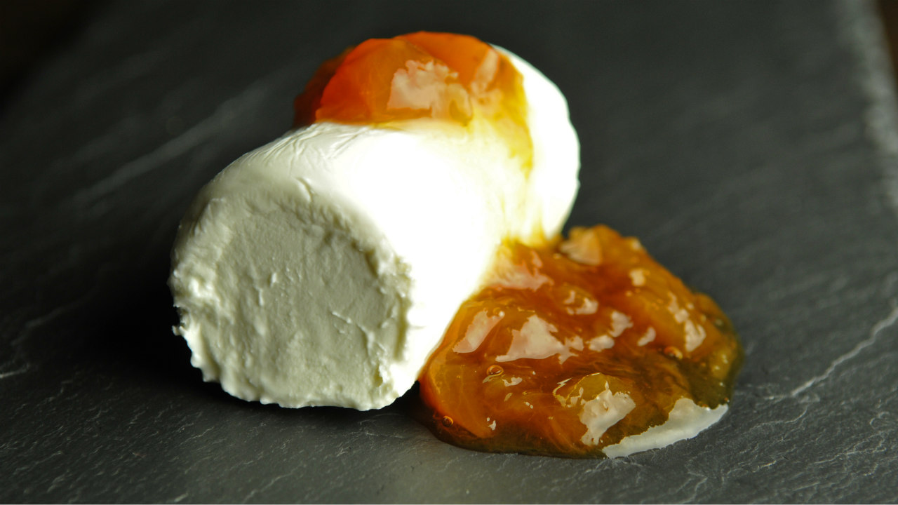A roll of creamy white goat cheese topped with apricot marmalade. Photo by Jim Klousia.
