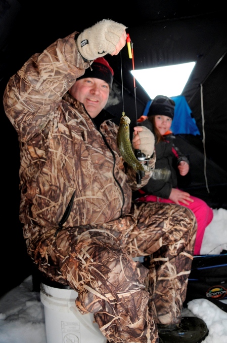 Mike Best, with daughter Paige, shows off one of the 66 fish the group caught in 1 hour.